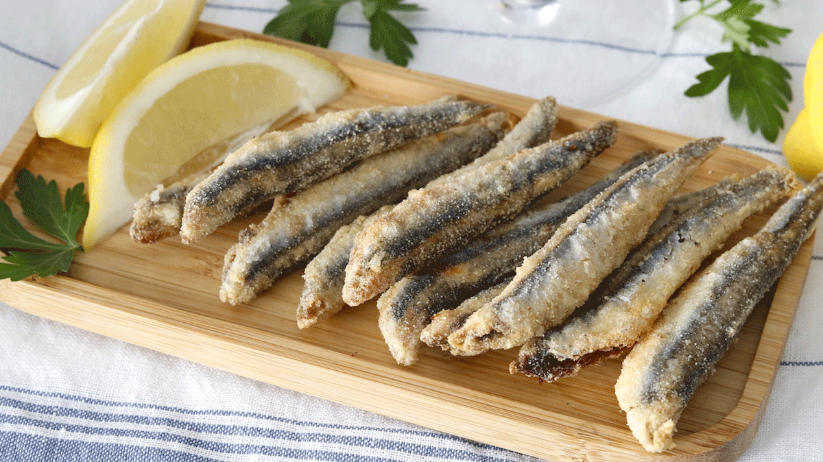 Boquerones fritos de Málaga en un plato blanco con rodajas de limón